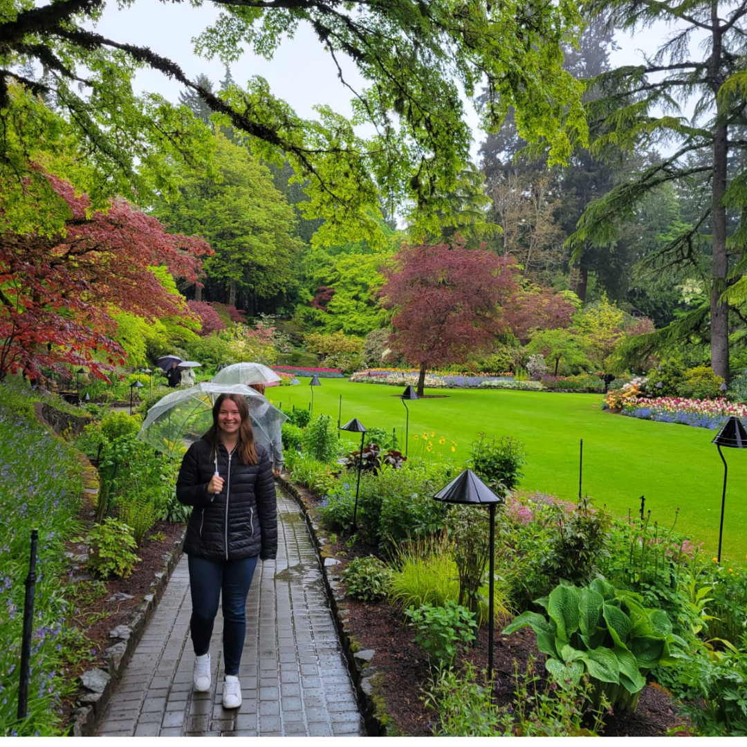 Picture of me walking through Butchart Gardens holding an umbrella.